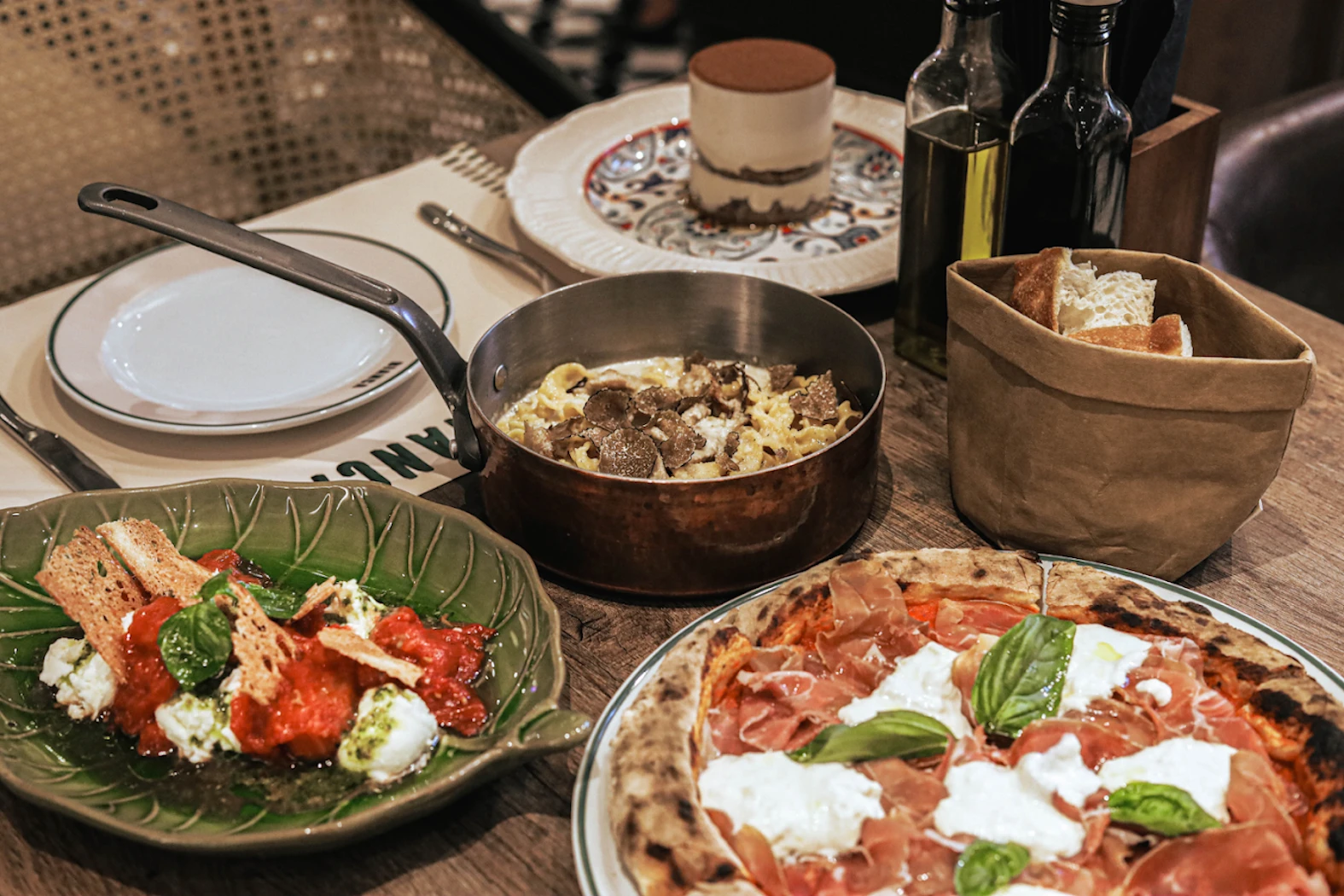 Classic Italian dishes like truffle pasta, mozzarella-ham pizza, and burrata. A chic setting for an Italian meal at Bianca restaurant in Bangkok